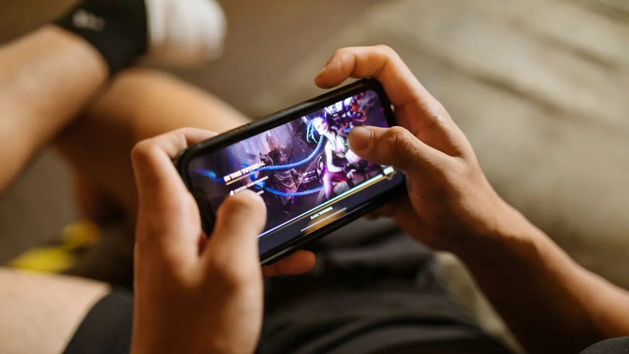 Close-up of hands gripping a phone during a long mobile gaming session